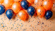 Colorful orange and electric blue balloons and confetti on a table