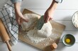 Woman cutting dough at white wooden table, top view