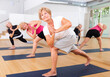 Senior women practicing yoga pose during group yoga training.