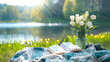 © tracy - A book is open on a blanket next to a vase of flowers. The scene is peaceful and relaxing, with the sun shining on the water and the flowers adding a touch of beauty to the setting
