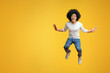 © Prostock-studio - Cheerful african-american curly guy jumping in air