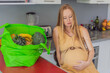 Exhausted but resilient, a pregnant woman feels fatigue after bringing home a sizable bag of groceries, showcasing her dedication to providing nourishing meals for herself and her baby