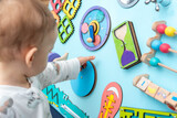 Fototapeta Miasto - Baby with a small hand reaches for a busy board