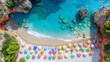The flat top aerial view of a beautiful beach with crystal blue water and colorful umbrellas built on the sand