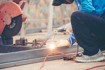 Wall Mural - Men hands wear protective glove Hot flame metal work cutting fire iron workshop. Locksmith use Welding machine cut metal process. Construction Worker hands using Welding machinery iron metal sparking