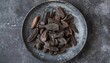 Close up of dried tonka beans on a gray plate from a top perspective