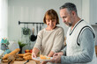 © Kawee - Caucasian senior elderly couple spend time together in kitchen at home.
