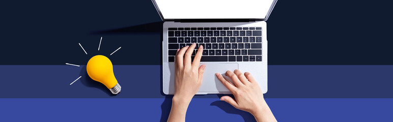 Poster - Person using a laptop computer and a light bulb - Flat lay