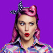 Wow! Excited surprised woman. Pinup girl looking sideways. Purple head model at retro fashion and vintage concept. Isolated against bright color background. Square image.