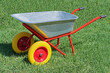 Garden metal wheelbarrow on a lawn with grass
