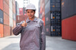 Portrait Asia logistic engineer woman worker or foreman working with thump up at container site	