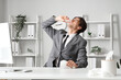 © Pixel-Shot - Sick businessman with tissue using nasal drops in office