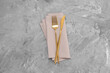 Beautiful cutlery set and kitchen towel on grey table, top view