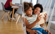 African american mother and daughter watching entertainment on digital tablet at home