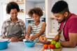 Happy african american family preparing healthy food in kitchen, having fun together on weekend