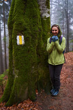 Fototapeta  - Woman hiker on a rainy day in the forest