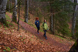 Fototapeta  - HIkers with backpacks on a trail in a rainy day