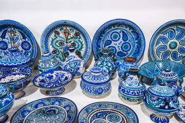 Wall Mural - Uzbek handmade ceramic plates and tableware with hand-painted traditional Asian blue patterns at bazaar in Uzbekistan in Tashkent