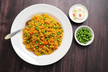 Wall Mural - Carrots and Peas Pilaf or Gajar Matar Pulao. It is a one pot rice dish made with Basmati Rice and Vegetables, seasoned with spices, Served with yogurt raita or curd. Healthy weight loss meal. copy