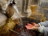 Fototapeta Uliczki - Catching Water from a Historic Stone Fountain