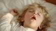 © Artem - Funny face expression with open mouth of blonde caucasian three years old child, sleeping on king bed