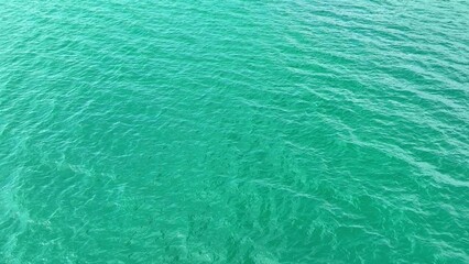 A sea wave, captured from a drone's lofty perspective, dances gracefully, an ode to nature's eternal love story. The sea breathes life, providing global oxygen. Tropical and nature concept. 
