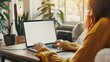 © Hamid - Businesswoman's hand using laptop with blank white screen on desk, businesswoman's hand using laptop with blank white desktop screen