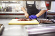 Hands, chef and cutting steak for restaurant with catering industry, board and fine dining for nutrition. Employee, knife and beef in industrial kitchen for hospitality, dinner and cooking career