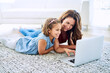 Mother, girl and laptop for education in home, online class and remote learning or care on floor. Daughter, mama and streaming cartoon or app for child development, bonding and support in childhood