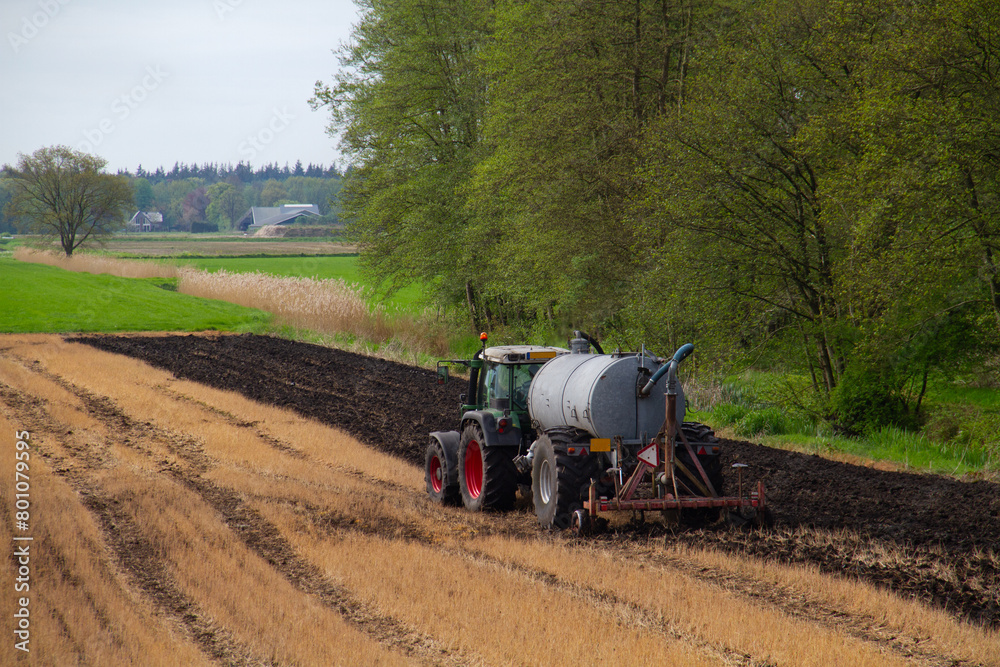 Field Getting Sprayed Tractor with slurry tank preparing field treated with glyphosate for ...