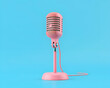 Pink retro microphone isolated on blue background. 3d render illustration.