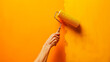 Person painting a wall with orange paint