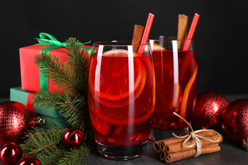 Wall Mural - Delicious Sangria drink in glasses and Christmas decorations on dark table, closeup