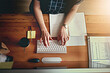 Woman, hands and keyboard at desk for schedule, planning and research for project in office. Graphic designer, typing and computer with documents in creative agency for email, notebook and networking