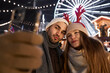 Young couple taking selfie on Christmas Market at night
