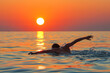 Morning swim: swimmer dives into calm waters as sun peeks over horizon.