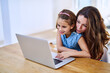 Funny, mother and happy girl with laptop in home, internet and child with woman for meme or video and childhood development. Search, technology and browse for fun, streaming and bonding together