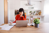Fototapeta Koty - Woman working remotely from home doing paperwork