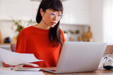 Fototapeta Koty - Woman doing paperwork while working remotely from home