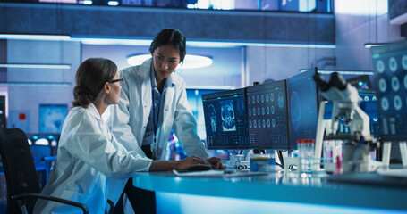 Poster - Asian And Caucasian Female Doctors Talking In Medical Research Center And Using Desktop Computer To Analyze MRI Scans Of Brain. Surgeon And Neuroscientist Discussing Solutions For Brain Tumor Patients