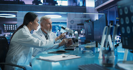 Aufkleber - Biotechnology Medical Research Center: Female Asian Neuroscientist Using Desktop Computer And Talking To Male Caucasian Doctor With Microscope. Specialists Developing Innovative Cancer Treatment.