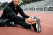 © Rawpixel.com - Woman warming up by stretching on a running track