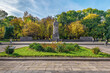 Lviv, Ukraine - November 2, 2023: Monument to Ivan Franko against the backdrop of the autumn Ivan Franko Park in Lviv. People walk along the square near the statue of the famous writer on a sunny day