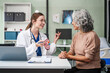 © NanSan - Caucasian woman and elderly Asian woman discuss kidney model issues like gallstones, glomerulonephritis, acute/chronic kidney disease, infections, abnormal ureters, cysts, urinary system cancer.