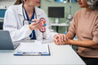 © NanSan - Caucasian woman and elderly Asian woman discuss kidney model issues like gallstones, glomerulonephritis, acute/chronic kidney disease, infections, abnormal ureters, cysts, urinary system cancer.