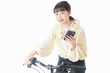 自転車でスマホを使う若い女性