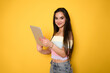 Smart intelligent caucasian hispanic latin-american young woman student using digital tablet isolated over yellow background.