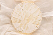 Brie cheese on white paper, macro, top view.