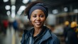 Portrait of a smiling African American woman wearing a blue headscarf in a warehouse