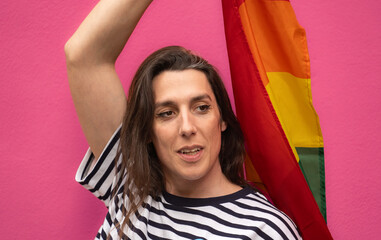 Poster - Headshot of a happy transgender woman holding a rainbow flag isolated on pin background